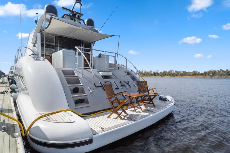 Slide: The Image of Luxurious 2010 Mangusta 72 Express yacht docked by serene waters under blue skies. - 6