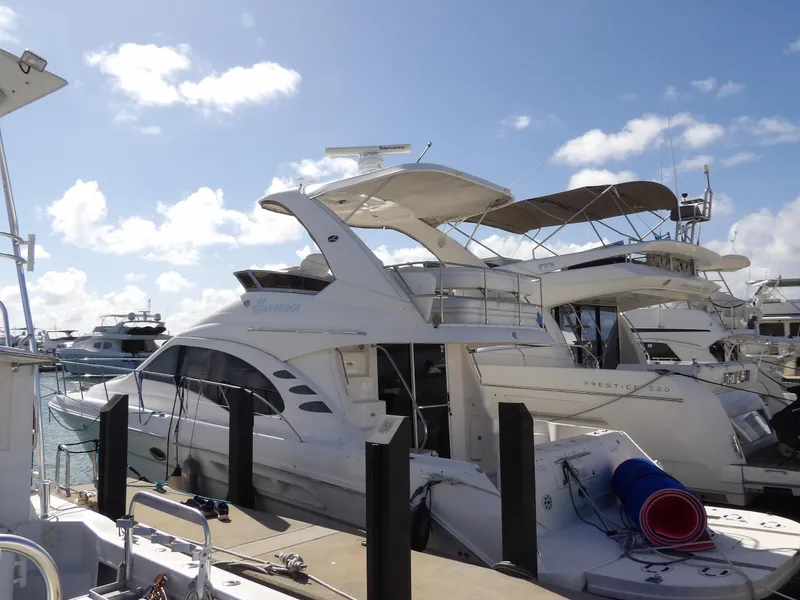Slide: The Image of 2008 Sea Ray 44 Sedan Bridge yacht docked at marina under blue sky. - 1