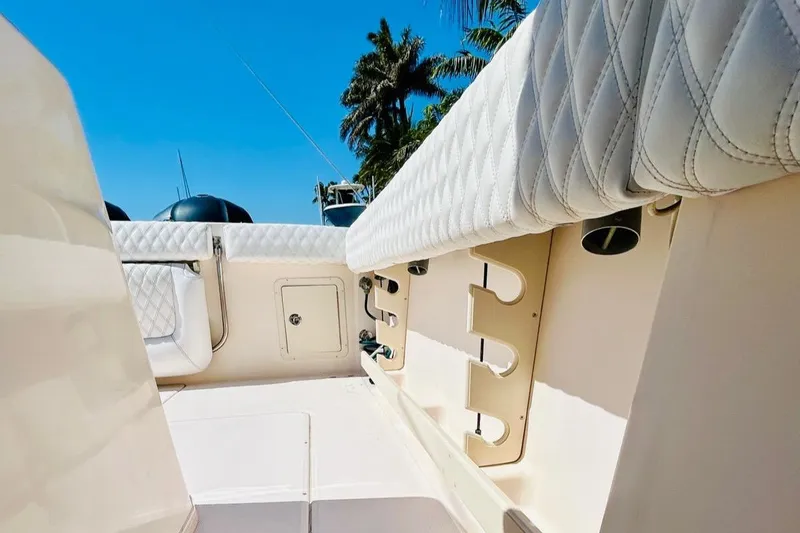 Slide: The Image of 2012 Grady-White Canyon 366 boat interior with rod holders and cushioned seating. - 19