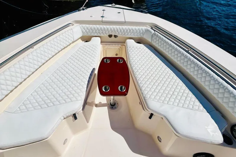 Slide: The Image of 2012 Grady-White Canyon 366 boat interior with white cushioned seating and a central table. - 34