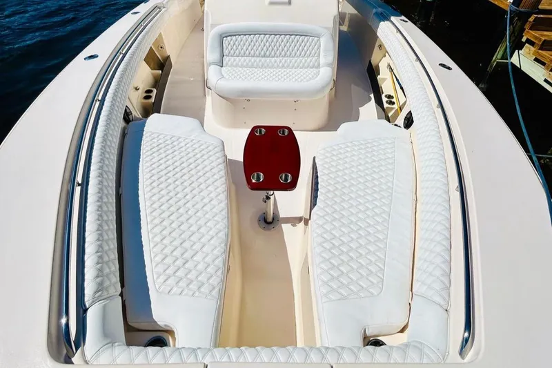 Slide: The Image of 2012 Grady-White Canyon 366 boat interior with white cushioned seating and small table. - 35