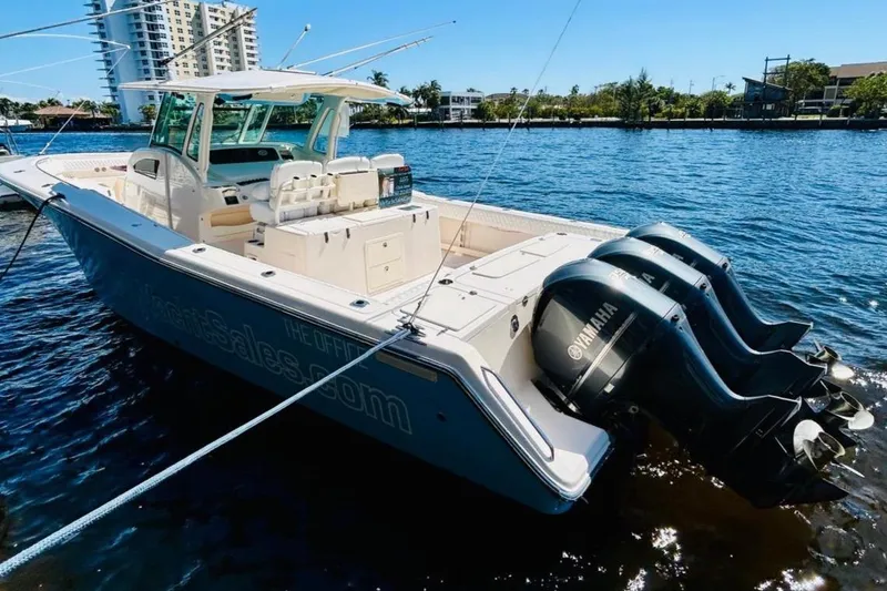 Slide: The Image of 2012 Grady-White Canyon 366 boat with triple Yamaha engines docked on water. - 4