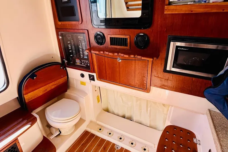 Slide: The Image of 2012 Grady-White Canyon 366 boat interior with wood paneling and compact amenities. - 43