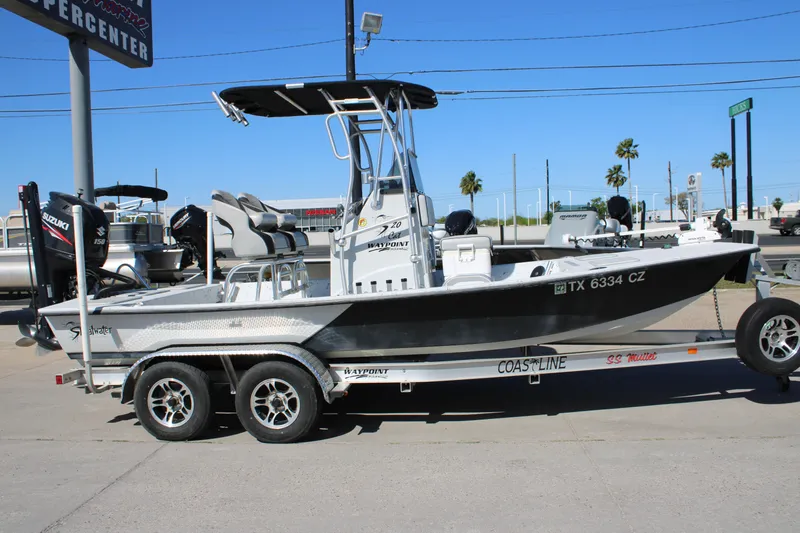 Slide: The Image of 2015 Shoalwater 20 Catamaran on trailer, parked outdoors, featuring Suzuki engine. - 20