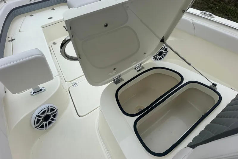 Slide: The Image of 2026 ShearWater 260 SS Carolina boat interior with open storage compartments and speaker. - 28