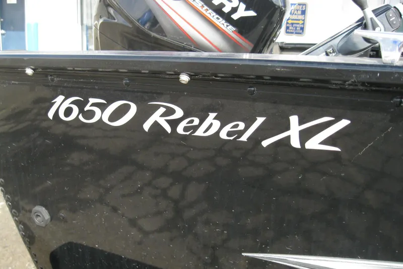Slide: The Image of 2015 Lund 1650 Rebel XL Tiller boat with Mercury engine branding. - 3