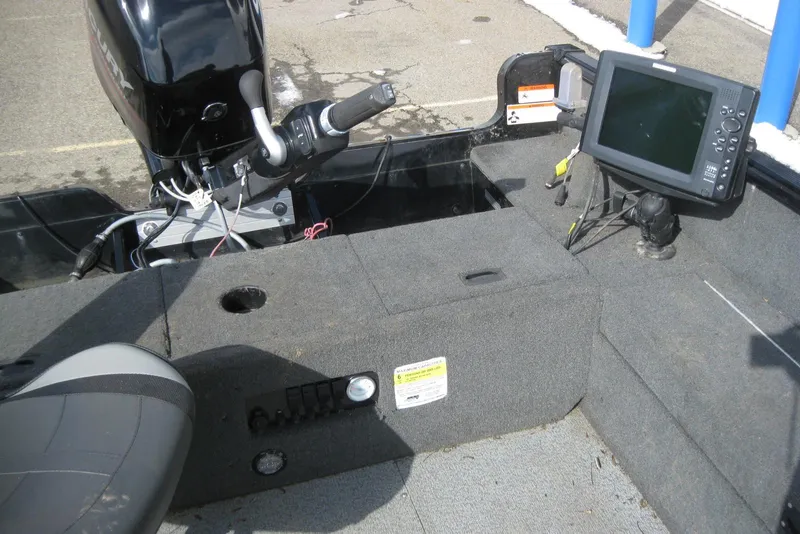 Slide: The Image of 2015 Lund 1650 Rebel XL Tiller boat interior with motor and navigation equipment. - 8