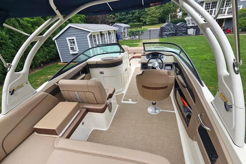 Slide: The Image of 2017 Sea Ray SDX 240 Outboard boat interior with beige seating and modern dashboard. - 25