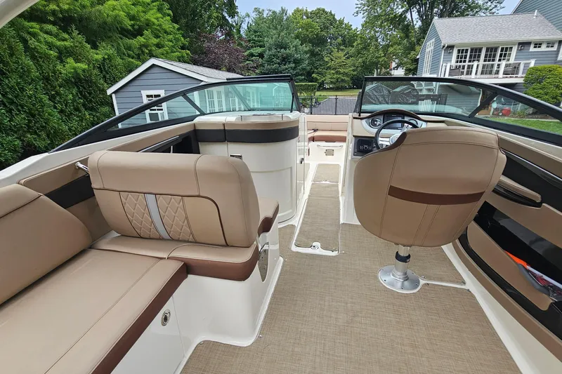 Slide: The Image of 2017 Sea Ray SDX 240 Outboard interior with beige seating and modern dashboard. - 27