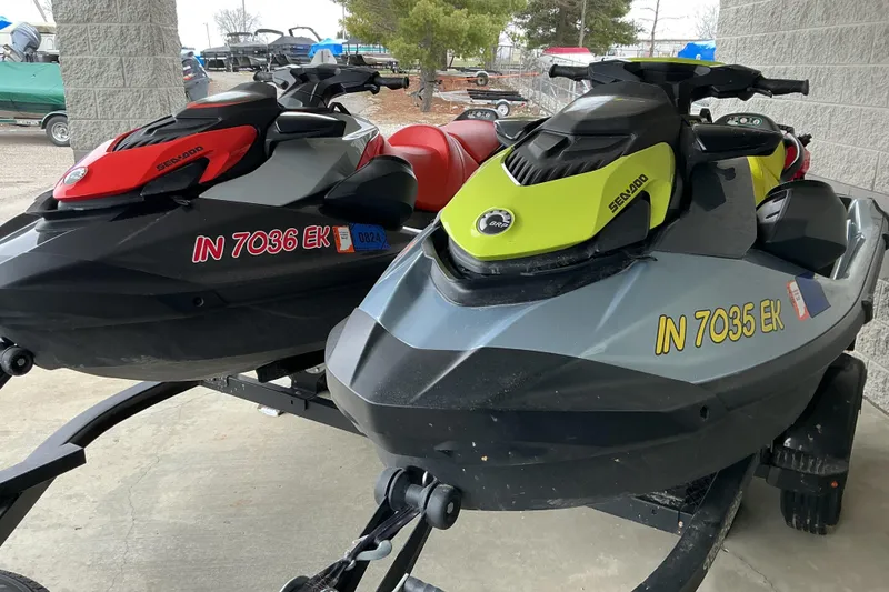 The Image of 2022 Sea-Doo GTI SE 170 jet skis in red and yellow on a trailer. - 1