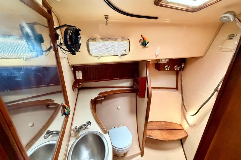 Slide: The Image of 1989 Island Packet Cutter bathroom with sink, toilet, and wooden accents. - 10