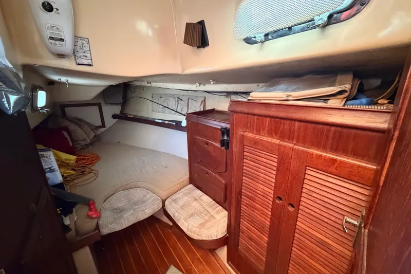 Slide: The Image of Cozy cabin interior of 1989 Island Packet Cutter with wooden cabinetry and bedding. - 12