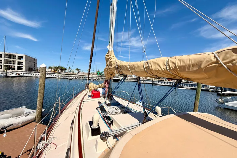 Slide: The Image of 1989 Island Packet Cutter sailboat docked at marina under clear blue sky. - 19