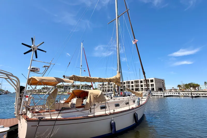 Slide: The Image of 1989 Island Packet Cutter sailboat docked in a marina under a clear blue sky. - 22