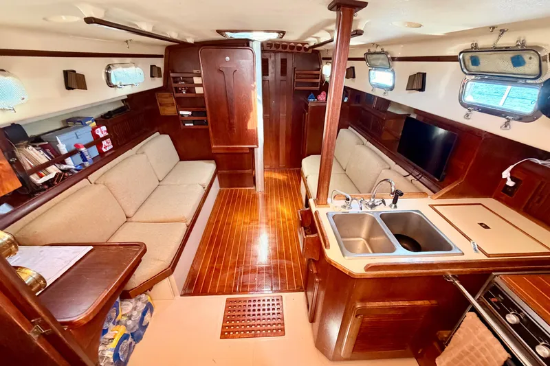 Slide: The Image of Interior of 1989 Island Packet Cutter sailboat with wood finish and cozy seating. - 4