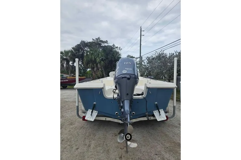 Slide: The Image of 2018 Bulls Bay 2000 boat with outboard motor, parked on gravel. - 2