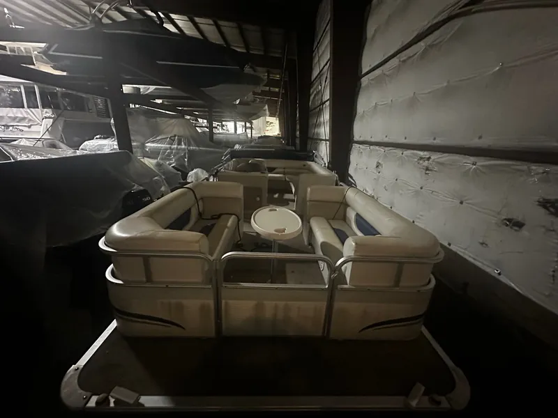 Slide: The Image of 2006 Sylvan 8522 Mirage Cruise RE pontoon boat in storage facility. - 2