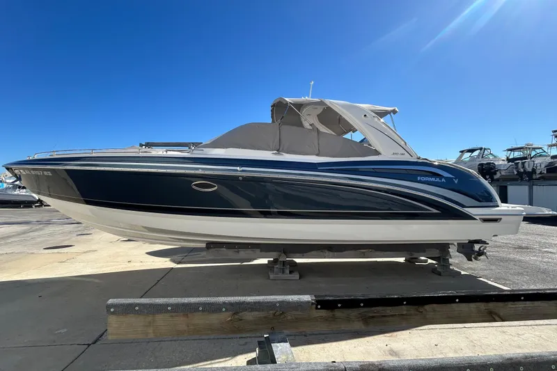 Slide: The Image of 2021 Formula 350 Crossover Bowrider I/O boat on display under clear blue sky. - 1