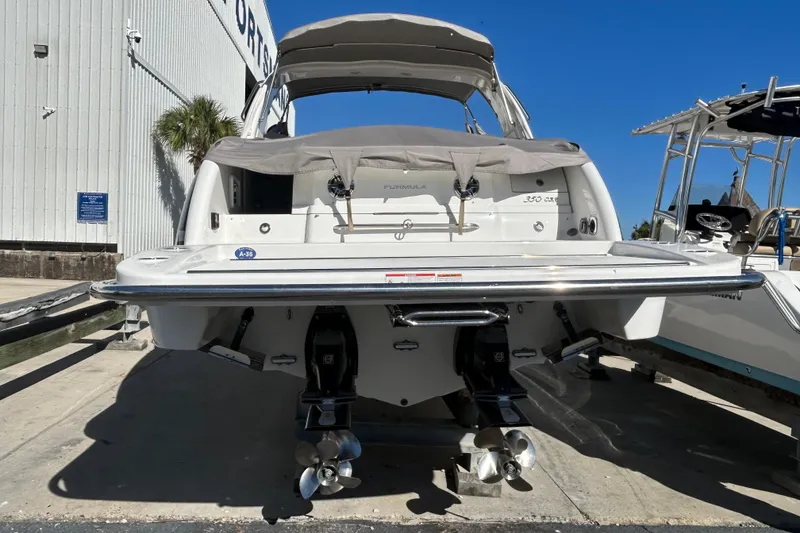 Slide: The Image of 2021 Formula 350 Crossover Bowrider I/O boat docked, rear view with dual propellers. - 4
