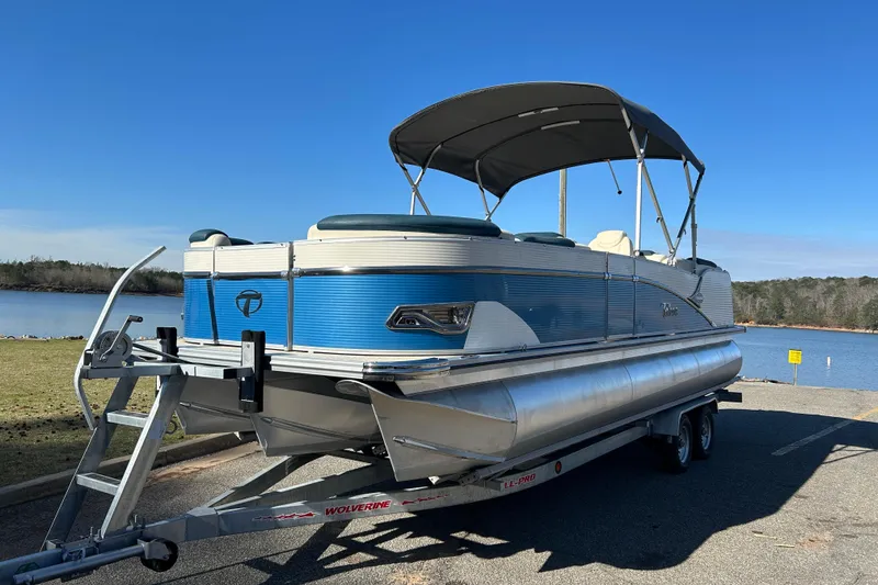 The Image of 2020 Tahoe Pontoon Cascade Platinum Quad Lounger 23' on trailer by a lake. - 0
