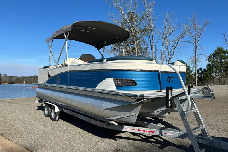 Slide: The Image of 2020 Tahoe Pontoon Cascade Platinum Quad Lounger 23' on trailer by a lake. - 2