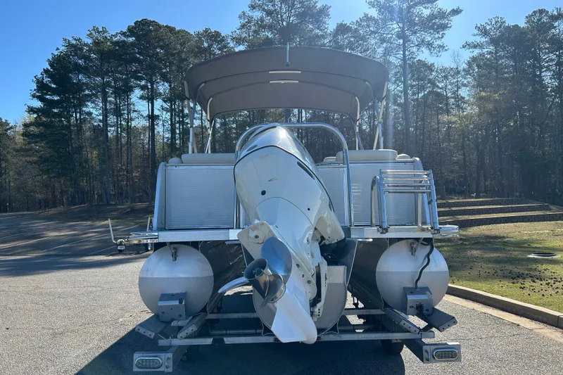 Slide: The Image of 2020 Tahoe Pontoon Cascade Platinum Quad Lounger 23' on trailer, parked near forest. - 5