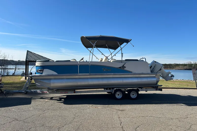 Slide: The Image of 2020 Tahoe Pontoon Cascade Platinum Quad Lounger 23' on trailer by a lake. - 7