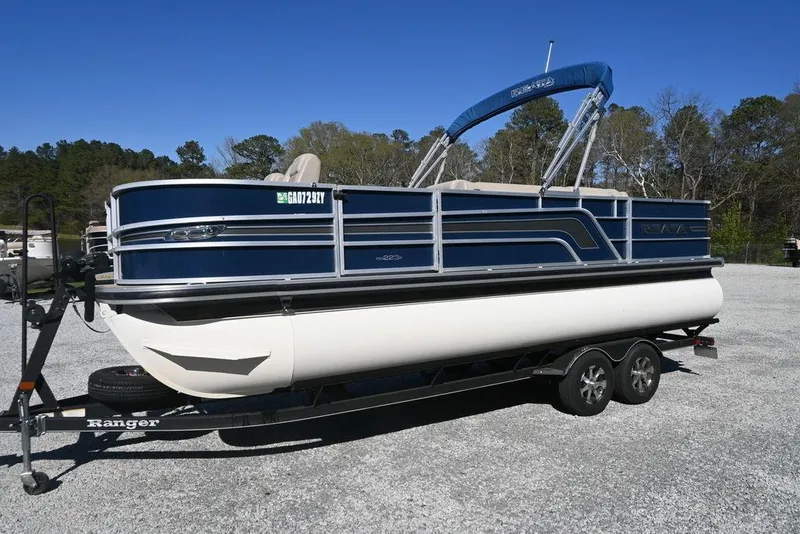 The Image of 2018 Ranger 223F pontoon boat on trailer in outdoor setting. - 1