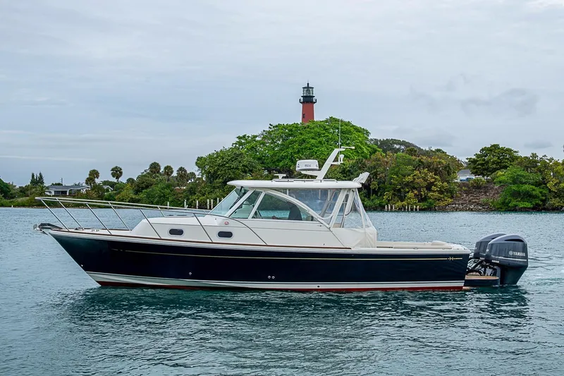 Slide: The Image of 2019 Hunt Yachts Surfhunter 32 cruising near a lighthouse on a calm waterway. - 1
