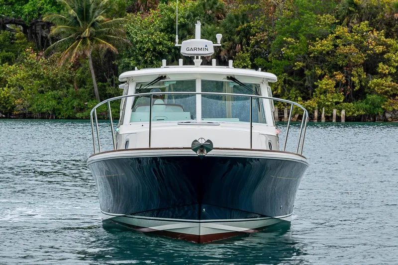 Slide: The Image of 2019 Hunt Yachts Surfhunter 32 cruising on a serene waterway, surrounded by lush greenery. - 10