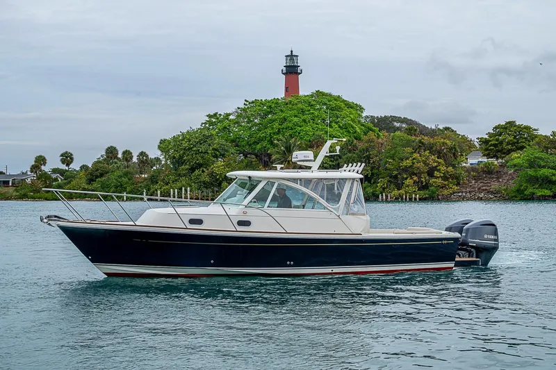 Slide: The Image of 2019 Hunt Yachts Surfhunter 32 cruising near a lighthouse with lush greenery. - 14