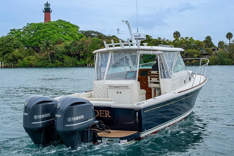 Slide: The Image of 2019 Hunt Yachts Surfhunter 32 with twin Yamaha engines cruising near a lighthouse. - 15