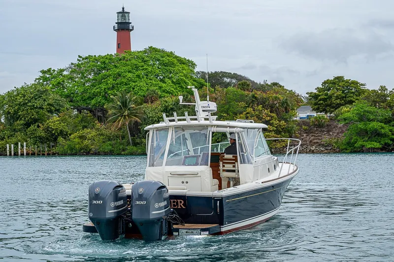 Slide: The Image of 2019 Hunt Yachts Surfhunter 32 cruising near a lush island with a lighthouse. - 16