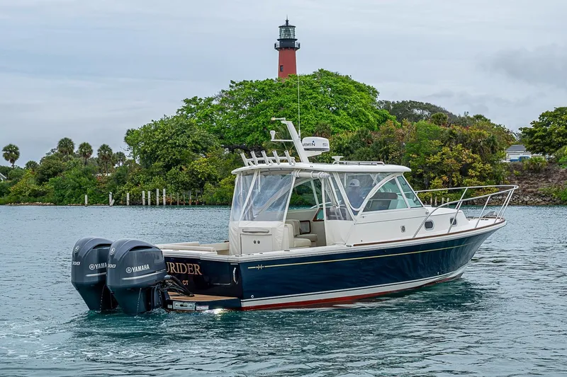 Slide: The Image of 2019 Hunt Yachts Surfhunter 32 cruising near a lighthouse, featuring twin Yamaha engines. - 18