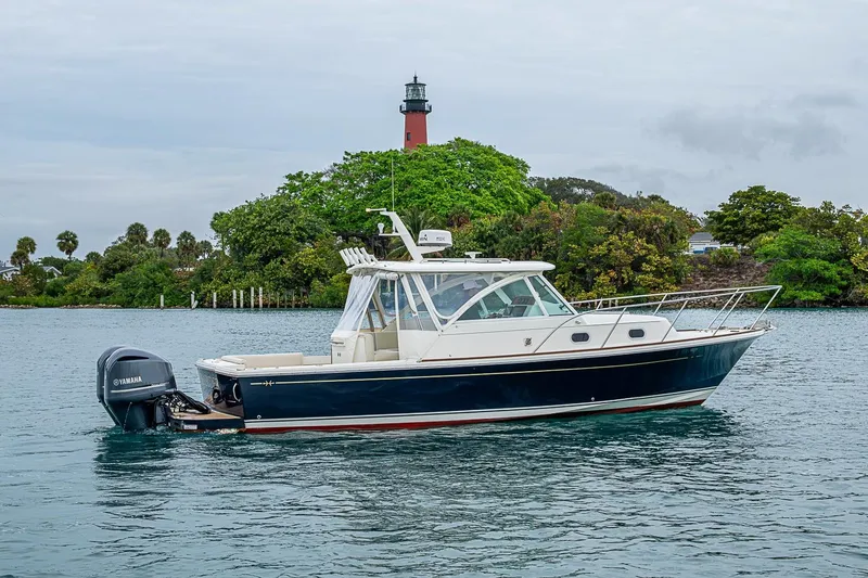 Slide: The Image of 2019 Hunt Yachts Surfhunter 32 cruising near a lush shoreline with a lighthouse. - 20