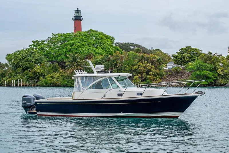 Slide: The Image of 2019 Hunt Yachts Surfhunter 32 cruising near a lighthouse with lush greenery. - 22
