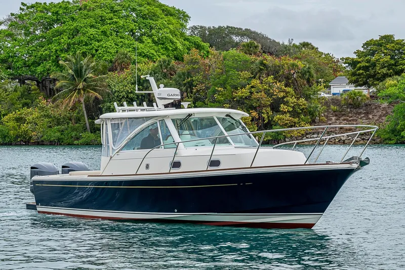 Slide: The Image of 2019 Hunt Yachts Surfhunter 32 cruising on a scenic waterway with lush greenery. - 23