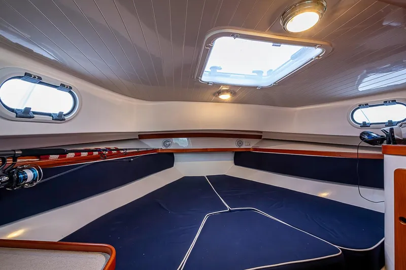 Slide: The Image of 2019 Hunt Yachts Surfhunter 32 cabin interior with blue cushions and natural light. - 38
