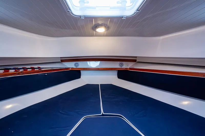 Slide: The Image of 2019 Hunt Yachts Surfhunter 32 cabin interior with blue cushions and overhead lighting. - 39