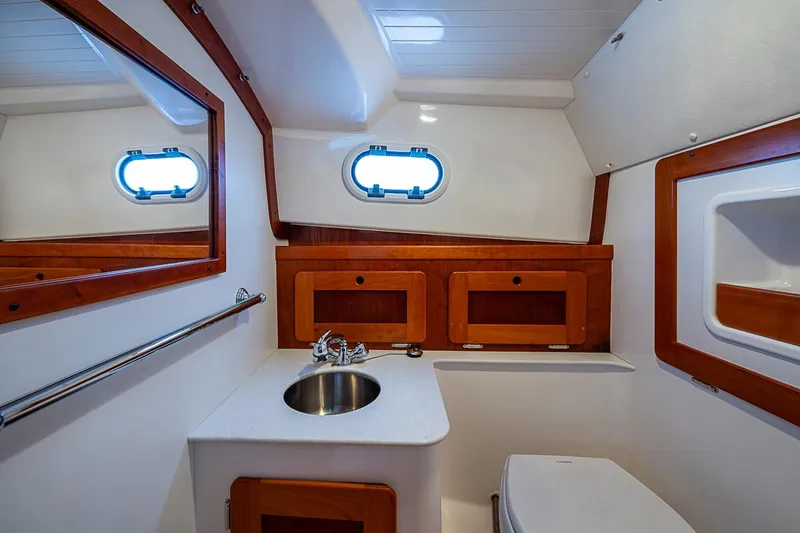 Slide: The Image of Luxurious bathroom interior of 2019 Hunt Yachts Surfhunter 32 with wooden accents and porthole window. - 42
