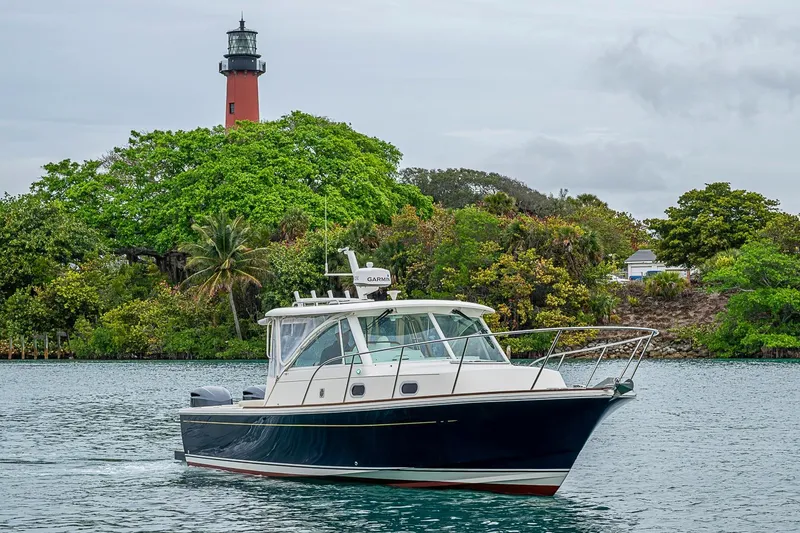 Slide: The Image of 2019 Hunt Yachts Surfhunter 32 cruising near a lush shoreline with a lighthouse. - 9