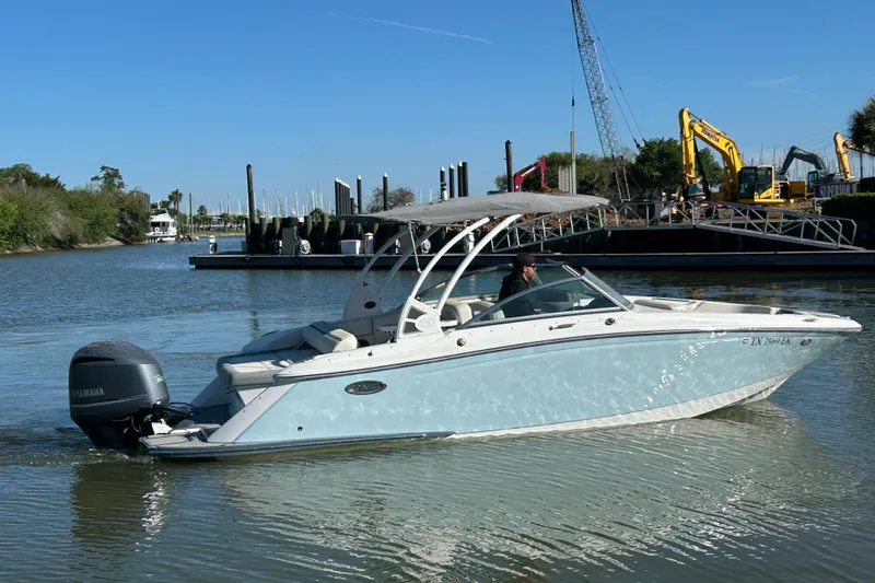 The Image of 2018 Cobalt 25SC boat cruising on a calm river near a construction site. - 0