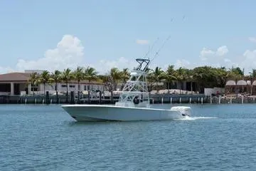 Slide: The Image of 2017 SeaVee 390Z boat cruising on a sunny day near a waterfront with palm trees. - 3