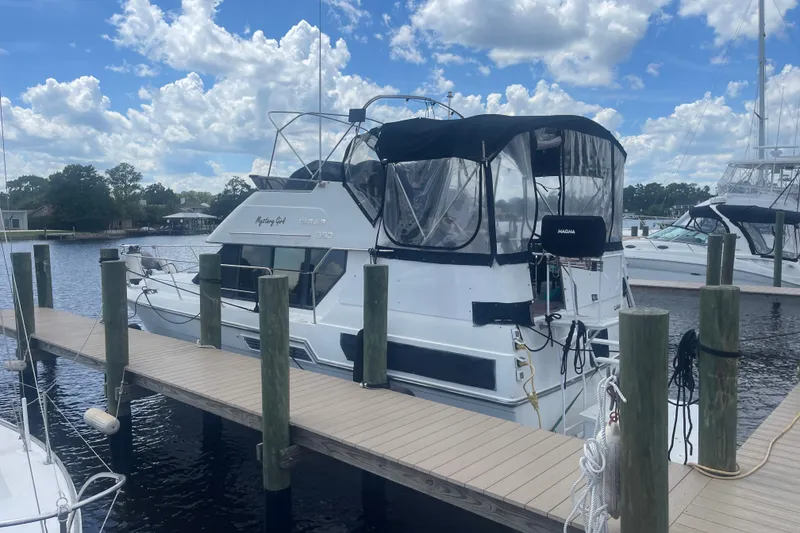 Slide: The Image of 1995 Carver 350 Aft Cabin Motor Yacht docked at marina under blue sky. - 4