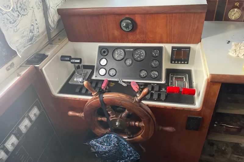 Slide: The Image of 1995 Carver 350 Aft Cabin Motor Yacht helm with wooden wheel and control panel. - 8