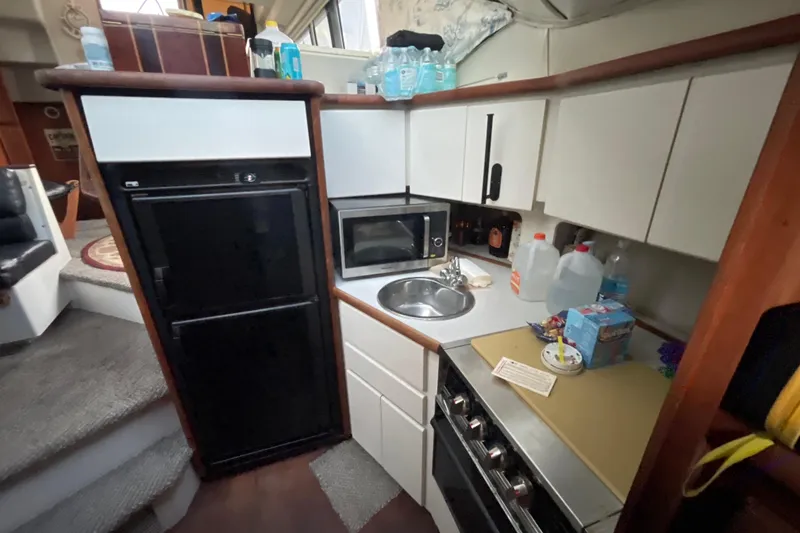 Slide: The Image of Compact kitchen in a 1995 Carver 350 Aft Cabin Motor Yacht with appliances and storage. - 9
