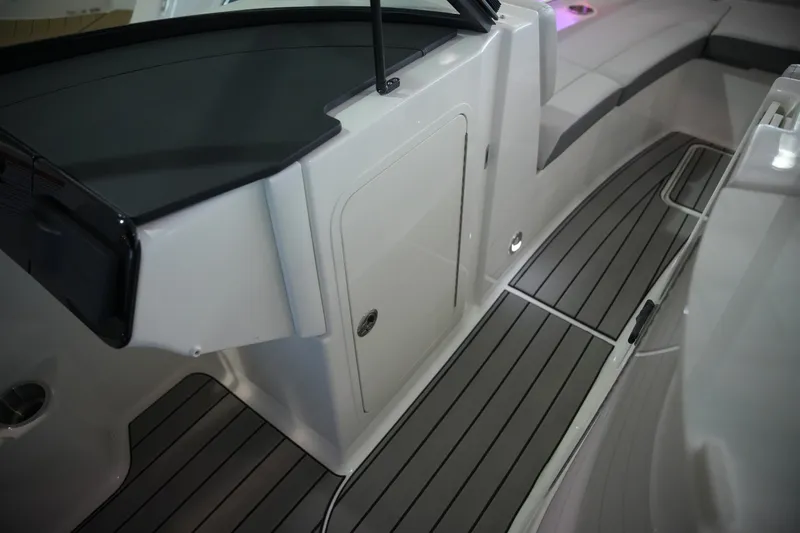 Slide: The Image of The image shows the interior of a 2026 Sea Ray SDX 270 boat with gray flooring. - 26