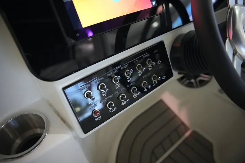 Slide: The Image of Close-up of a Sea Ray SDX 270 helm with various switches and a display screen. - 20