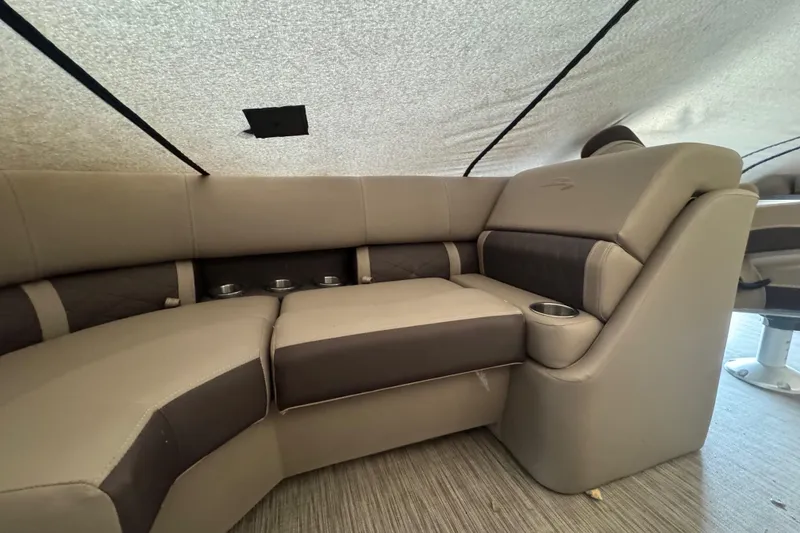 Slide: The Image of 2020 Bennington 22SSRXP boat interior with beige and brown seating, cup holders, and carpeted floor. - 13
