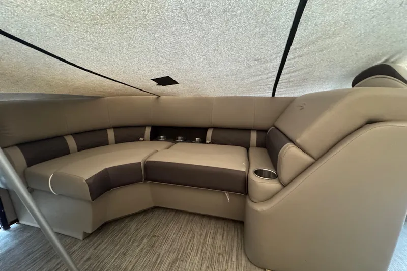 Slide: The Image of 2020 Bennington 22SSRXP boat interior with beige and brown seating, cup holders, and carpeted flooring. - 14